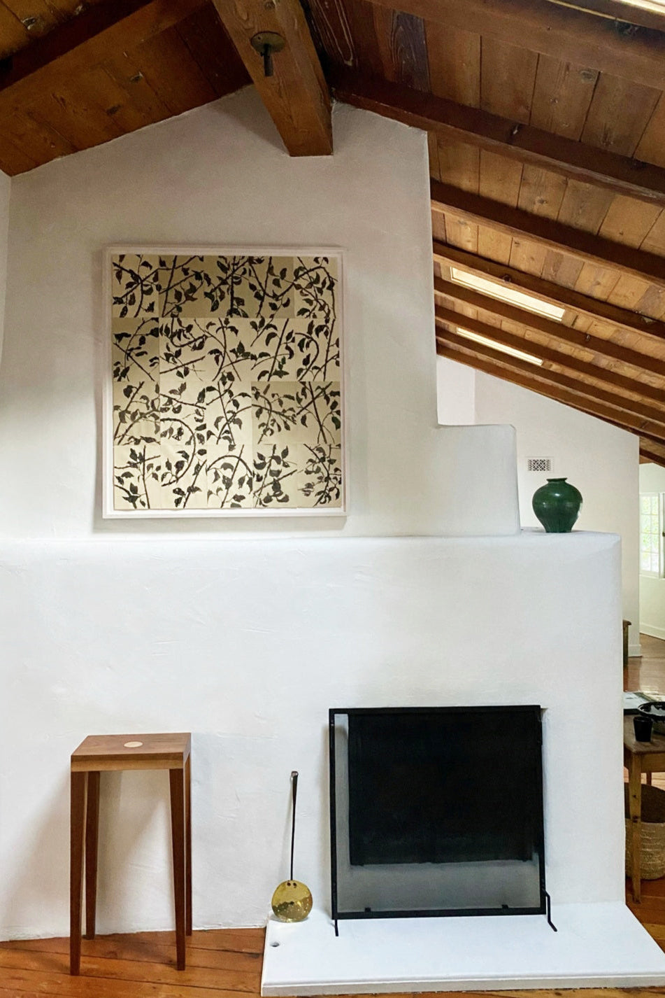 Modern living room with white fireplace, wooden ceiling beams, and decorative elements. Lucy Auge Artwork in Los Angeles Midcentury Home 